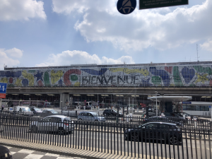 The entrance to terminals at Orly airport, colorful almost graffiti style and says "Bienvenue"